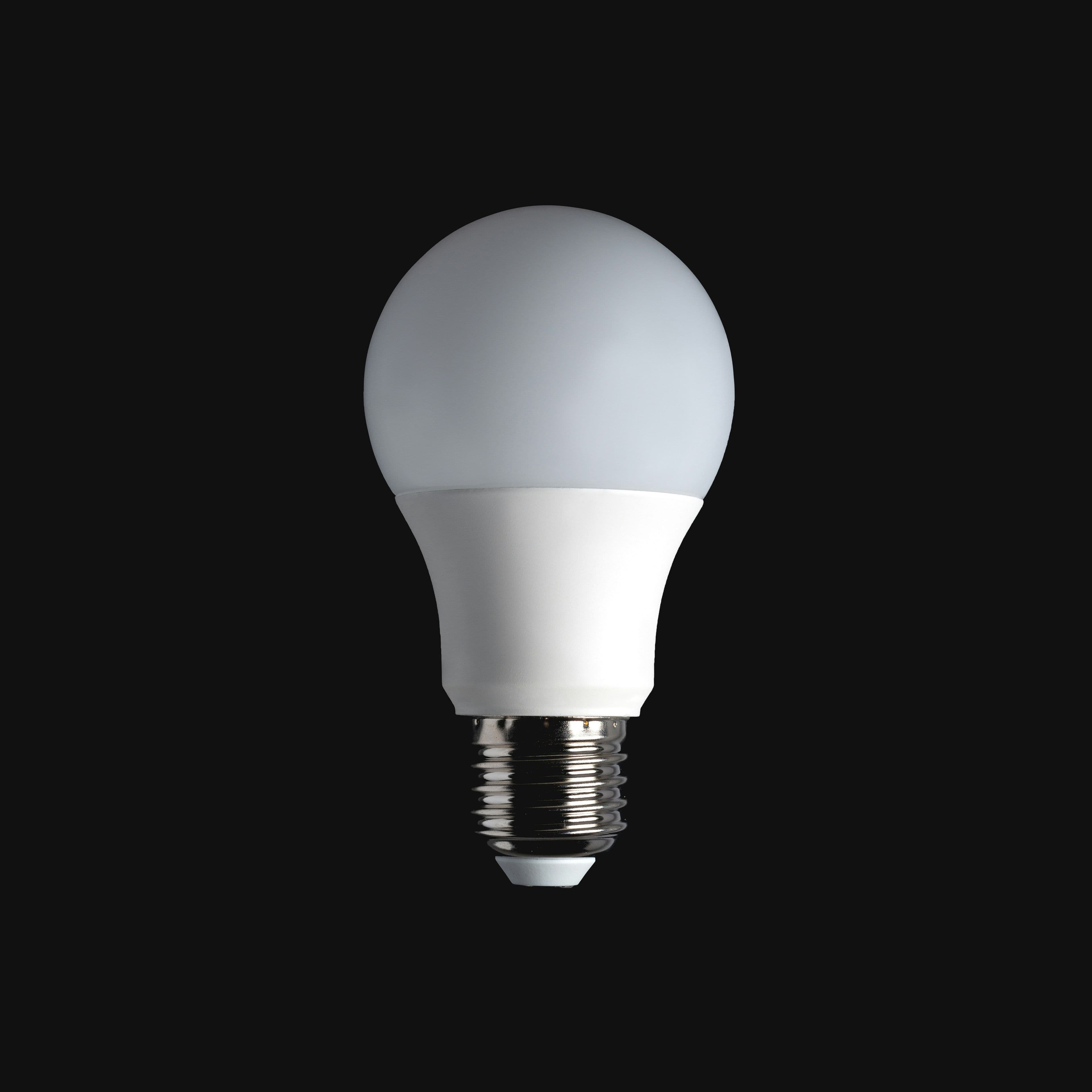 A smart LED bulb glowing warm white in a ceiling fixture