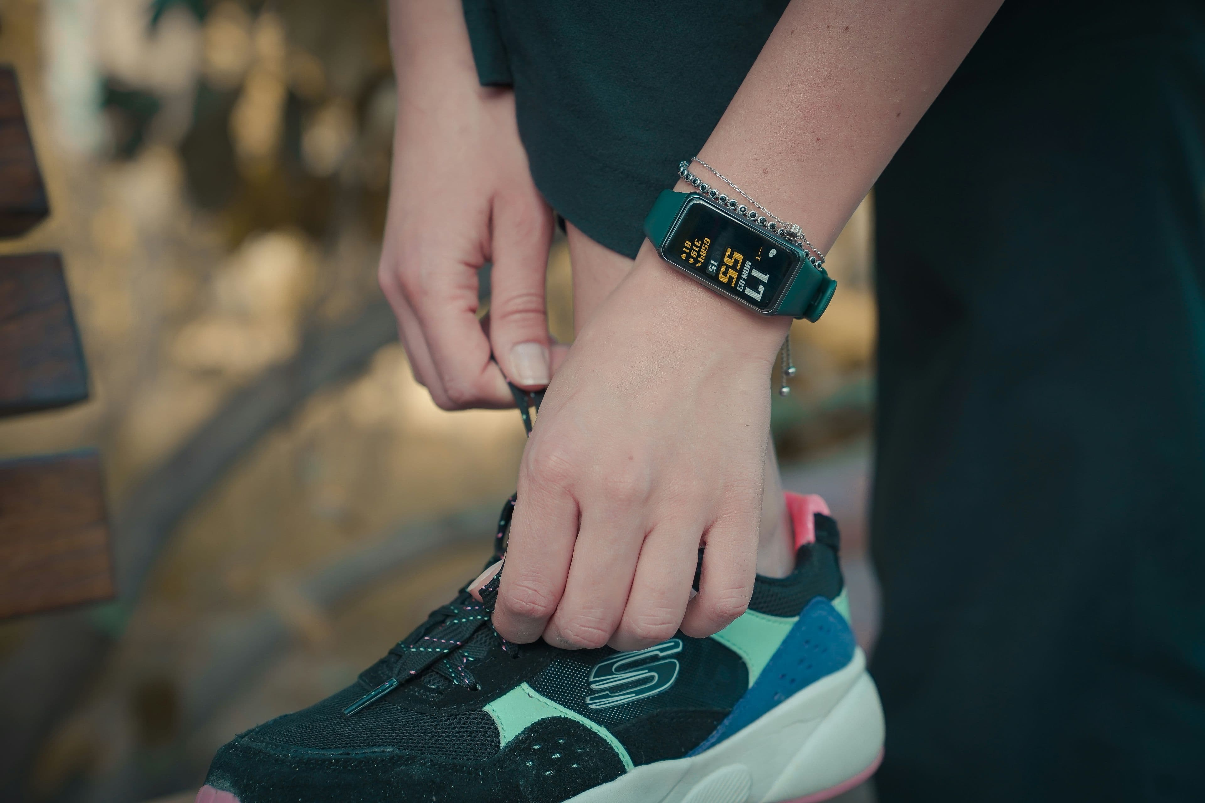 A smartwatch and a slim fitness band side by side on a table